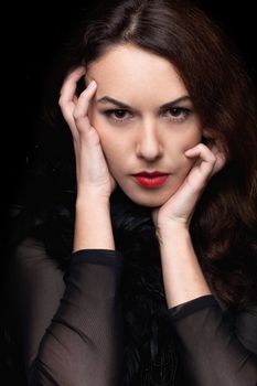 Closeup portrait of mysterious young woman. Isolated on black