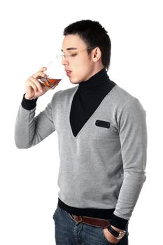 Young man drinking whiskey from a glass. Isolated