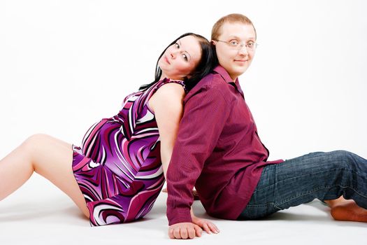 Young couple. A pregnant woman in a dress and a man. studio photography