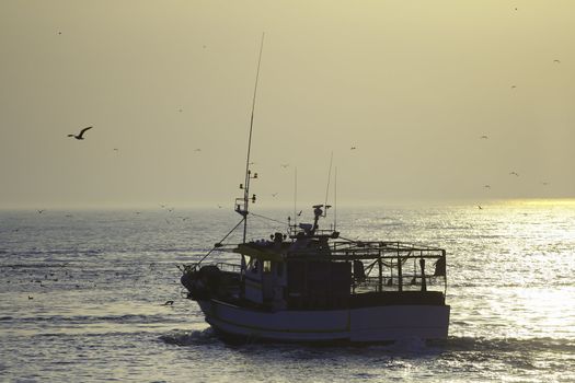 Fishing boat on the sunset departerd for a new day