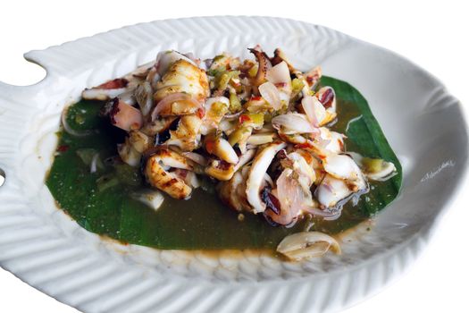 Plate of roasted cuttlefish with tamarind sauce, isolated on white background.