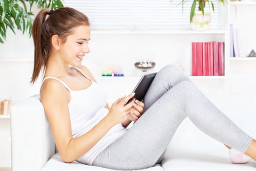 woman smiling while working on tablet computer at home
