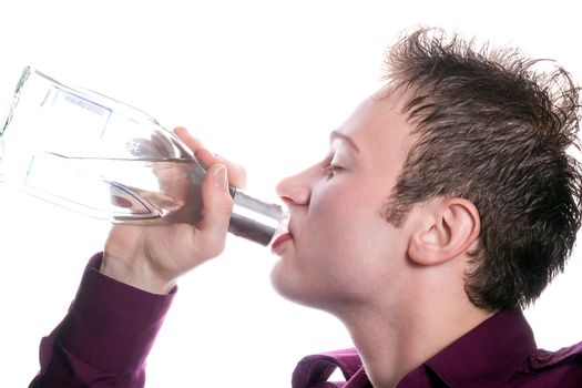 The young man drinks vodka from a bottle