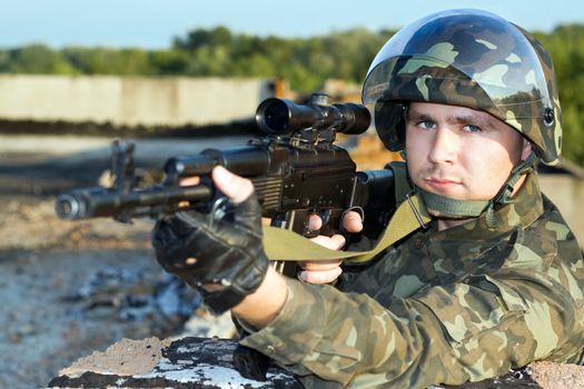 Portrait of the soldier in camouflage with machine gun