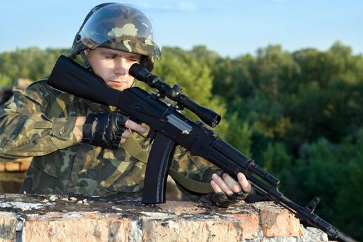 Portrait of sniper in camouflage uniform in action