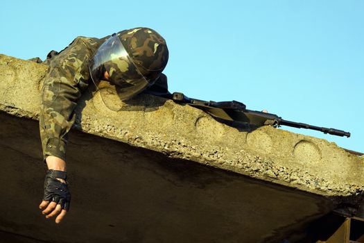 Lying dead soldier in camouflage uniform