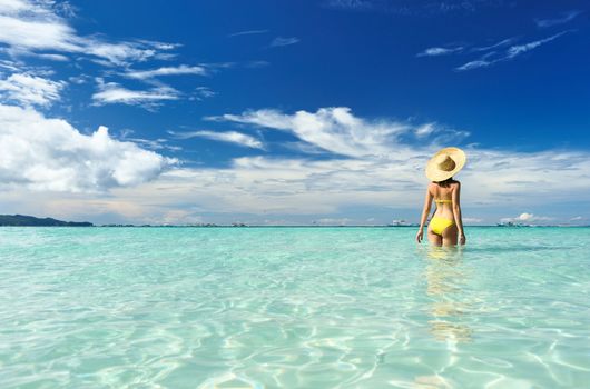 Girl on a tropical beach with hat
