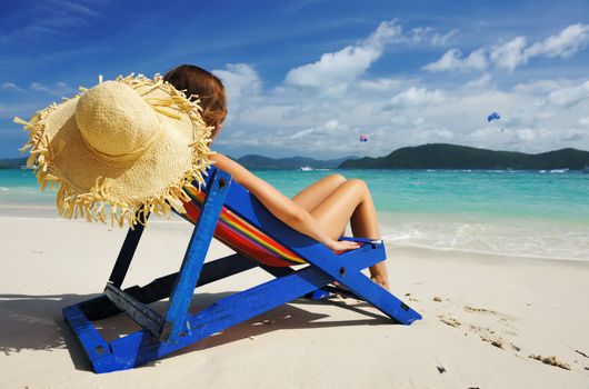 Girl on a tropical beach in chaise lounge