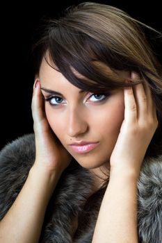 Close-up of young bewitching brunette. Isolated on black