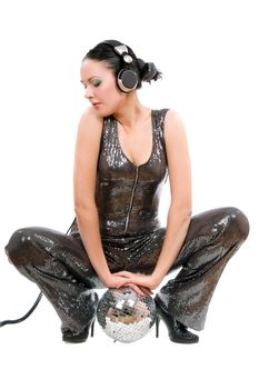 Beautiful young brunette in headphones with a mirror ball