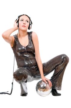 Nice young brunette in headphones with a mirror ball