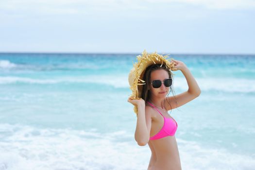 Girl on a tropical beach with hat