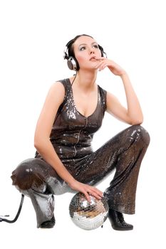 Young brunette in headphones with a mirror ball. Isolated