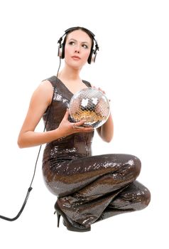 Beautiful young woman in headphones with a mirror ball. Isolated on white