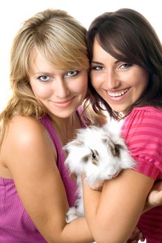 Two cheerful women embracing little rabbit. Isolated on white