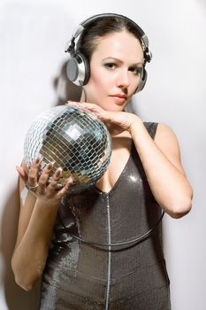 Portrait of beautiful brunette with a mirror ball in her hands