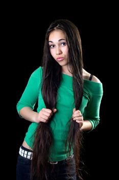 Playful  young woman holding her long hair. Isolated