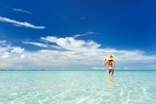 Girl on a tropical beach with hat