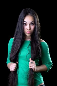 Young puzzled woman holding her long hair. Isolated