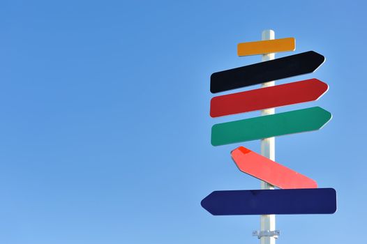 Arrow sign against blue sky