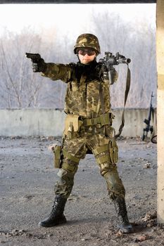 Military man aiming with two guns in abandoned house