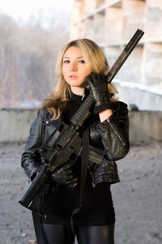 Hot woman in leather jacket holding a rifle