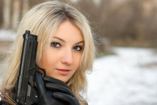 Sweet woman with a weapon in winter forest