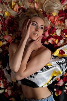 Portrait of seductive young woman lying in rose petals