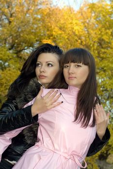 Two beauty young women outdoors in the autumn