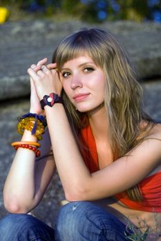 Pretty young woman sitting on the stones