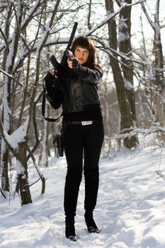 Armed beautiful young woman in winter forest