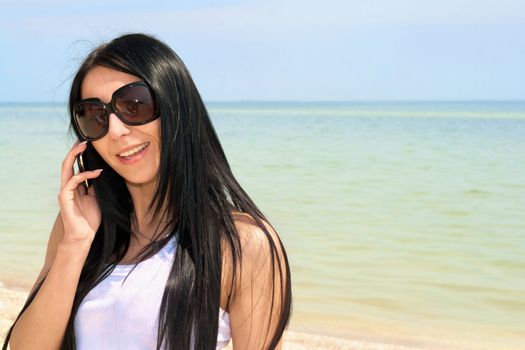 Portrait of smiling beautiful brunette speaking on the phone