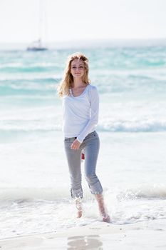 beautiful young woman walking on beach in summer vacation relaxing