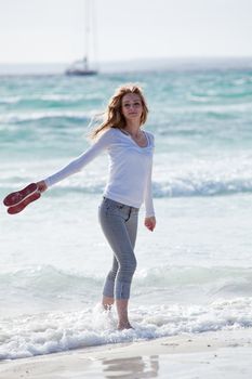 beautiful young woman walking on beach in summer vacation relaxing