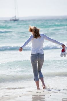 beautiful young woman walking on beach in summer vacation relaxing