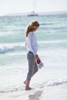 beautiful young woman walking on beach in summer vacation relaxing
