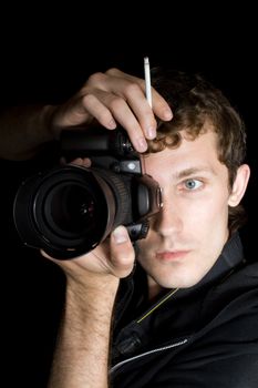The young man - photographer behind work. Isolated on a black background