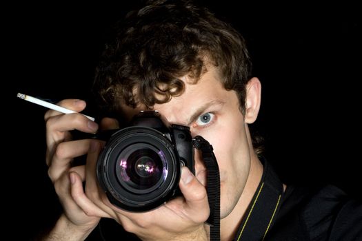 The young man - photographer behind work. Isolated on a black background 3