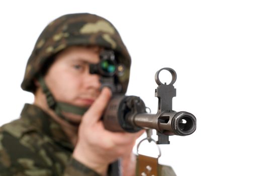 Armed soldier holding svd in studio. Focus on the rifle barrel