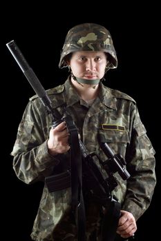 Armed soldier grasping m16 in studio. Isolated