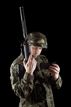 Soldier changing magazine of m16 in studio. Isolated