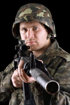 Soldier holding a gun in studio. Isolated