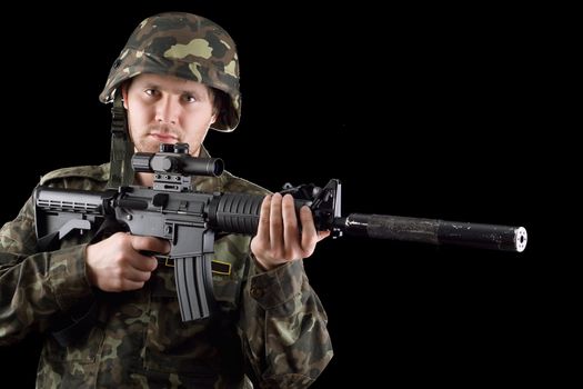 Alerted soldier holding m16 in studio. Closeup