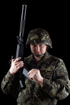 Soldier reloading magazine of m16 in studio. Isolated