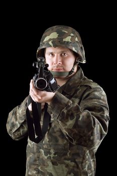 Armed man pointing a rifle in studio