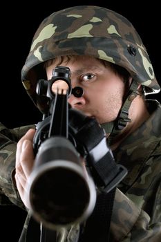 Man pointing a rifle in studio. Closeup