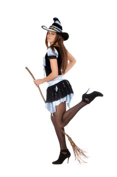 Playful beautiful young woman with a besom wearing costume witch