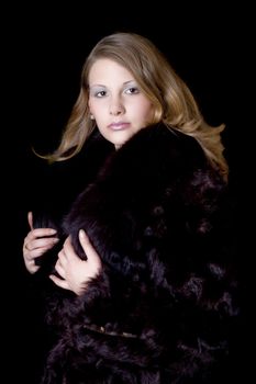 The young beautiful woman in a fur coat