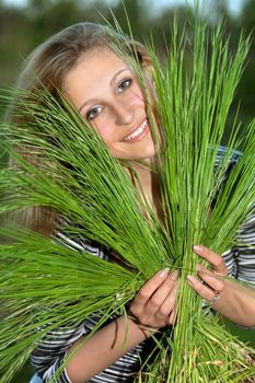 Cheerful blonde with green grass in their hands