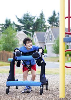 Disabled boy in walker walking up to a handicap inaccessible playground